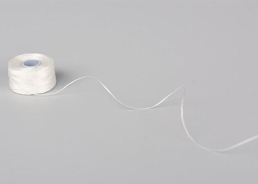 Spool of unraveling white thread